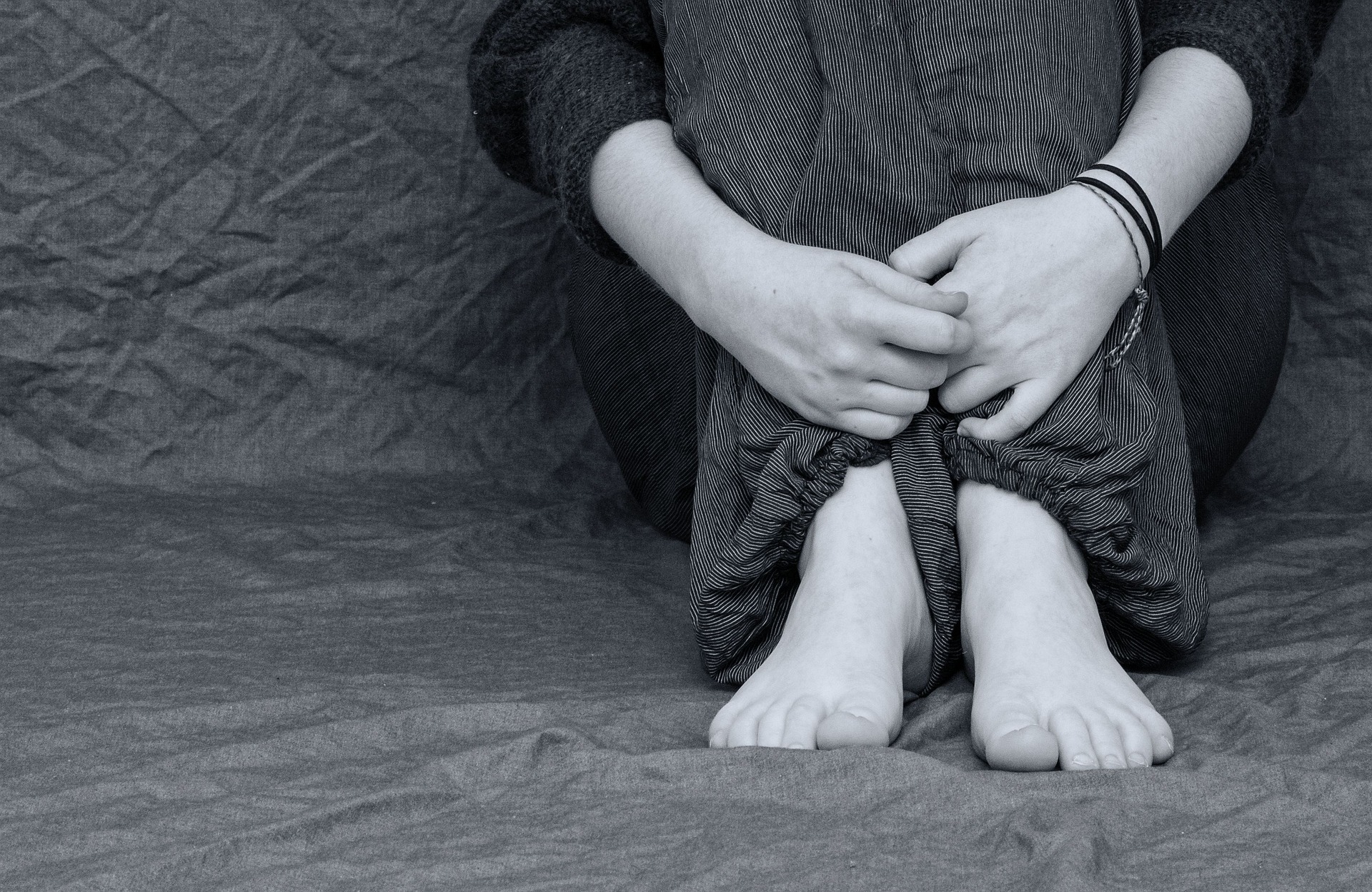 Silueta de mujer sentada abrazándose a sus piernas