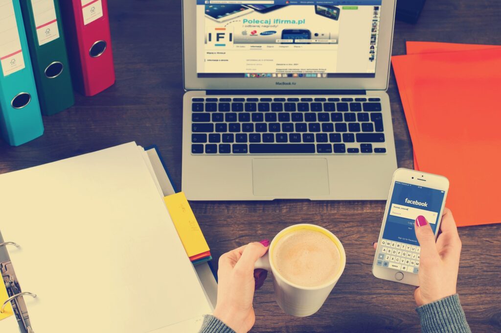 Laptop con café y móvil en la mano