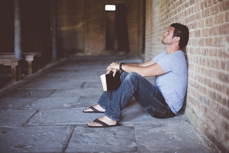 Persona que está sentada con un libro en la mano