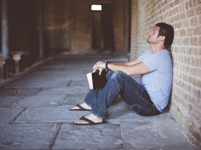 Persona que está sentada con un libro en la mano