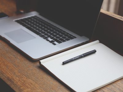 Un ordenador, y un cuaderno y lapicero